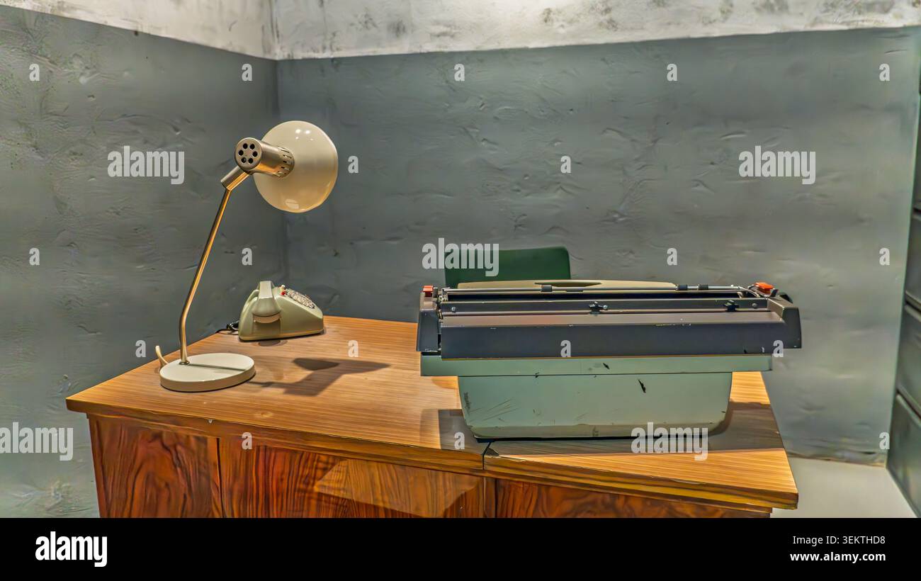 Macchina da scrivere vintage e telefono rotante sulla scrivania in interni d'ufficio retrò Foto Stock