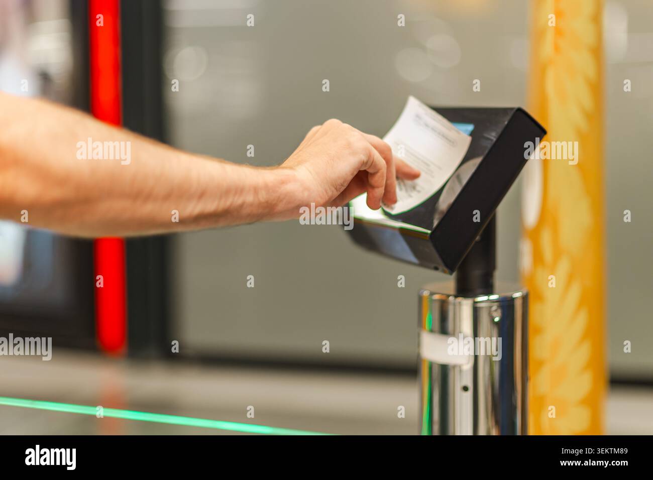 Uomo che esegue la scansione della ricevuta cartacea presso il terminale di cassa, utilizzando un sistema di vendita automatizzato per la verifica degli acquisti e la transazione sicura nei supermercati Foto Stock