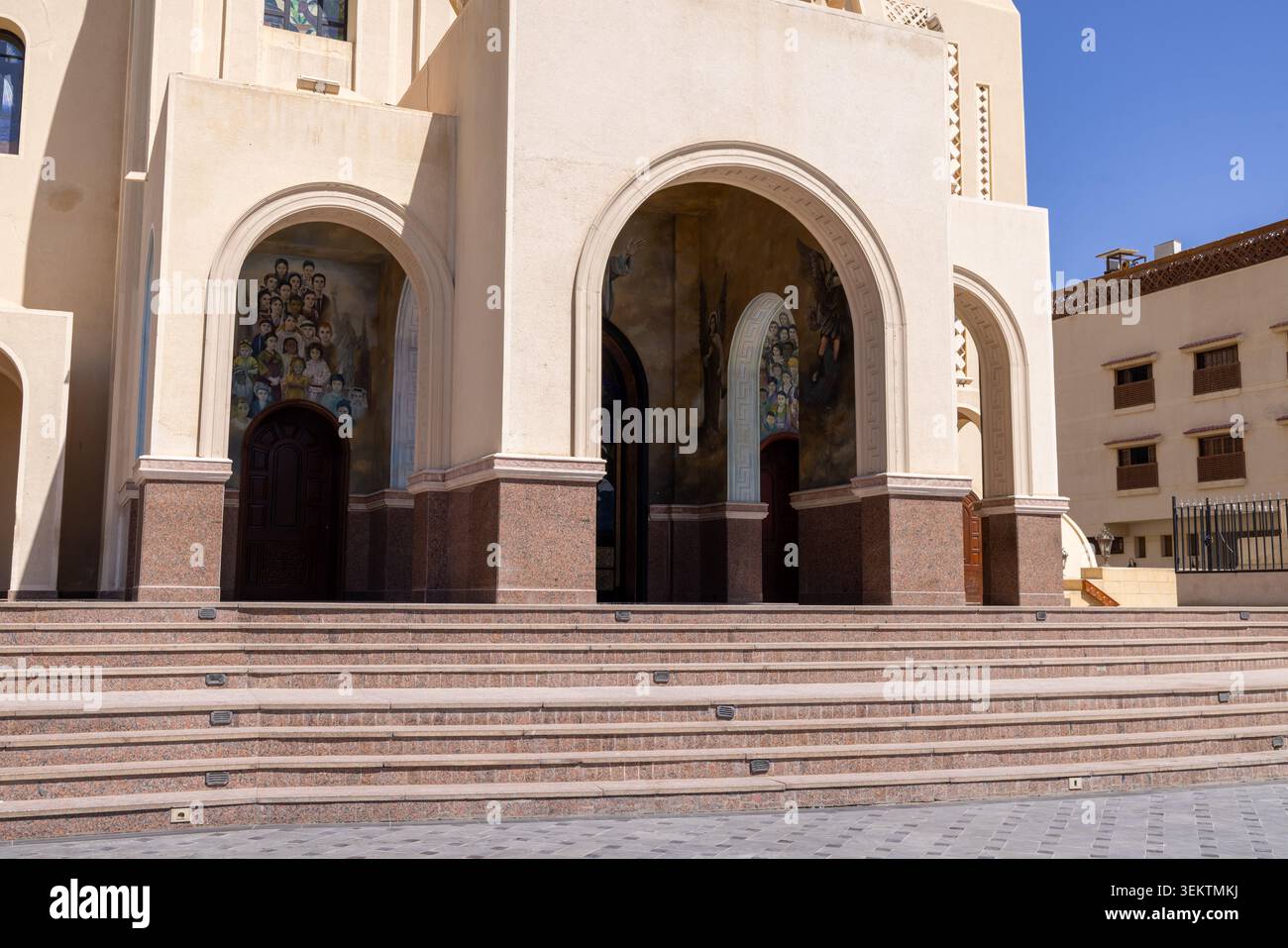 Sharm El Sheikh Egitto, 1 maggio 2026: Scalini d'ingresso e portico ad arco della Cattedrale celeste di Sharm El Sheikh Egitto con murales religiosi e Co Foto Stock