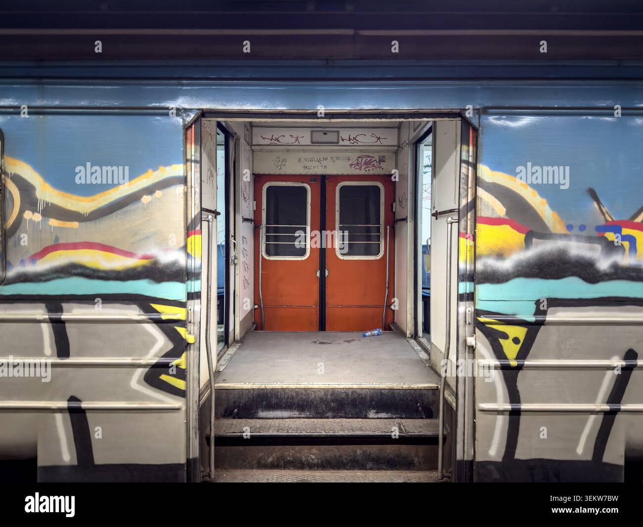 BELGRADO, SERBIA - 18 APRILE 2026: Porte aperte di un treno Beovoz o BG Voz in decadenza a Belgrado, con graffiti, superfici usurate e porte interne rosse. b Foto Stock