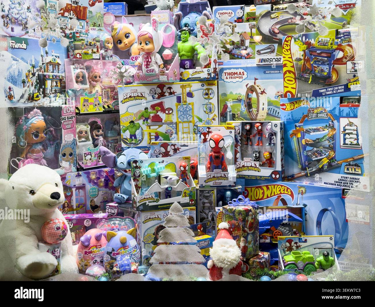 BELGRADO, SERBIA - 7 DICEMBRE 2025: Vetrina del negozio di giocattoli piena di merchandising Spidey, action figure, bambole, set Hot Wheels, peluche e gif in scatola Foto Stock
