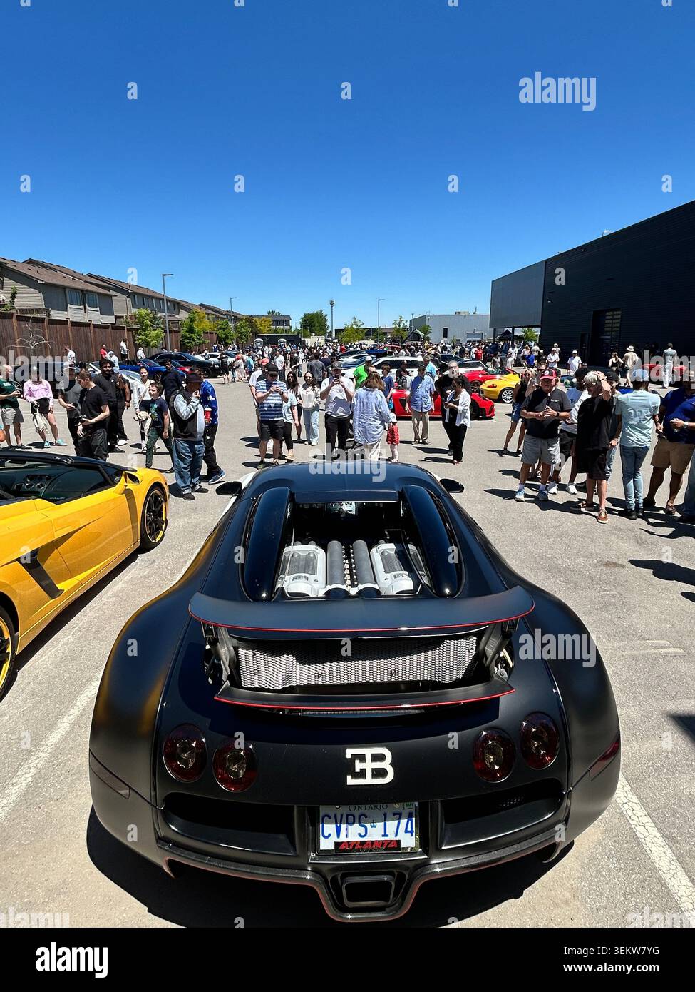 La supercar Bugatti Veyron nera parcheggiata all'affollata esposizione di auto all'aperto. Foto Stock