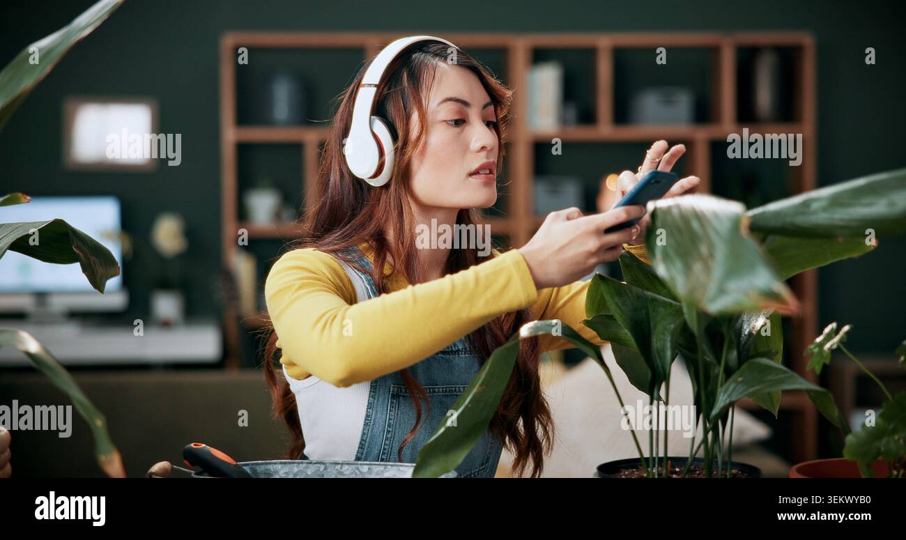 Donna, telefono e botanica con foto per piante, cuffie e creazione di contenuti per i social media. Influencer del giardinaggio, persona e tecnologia audio Foto Stock