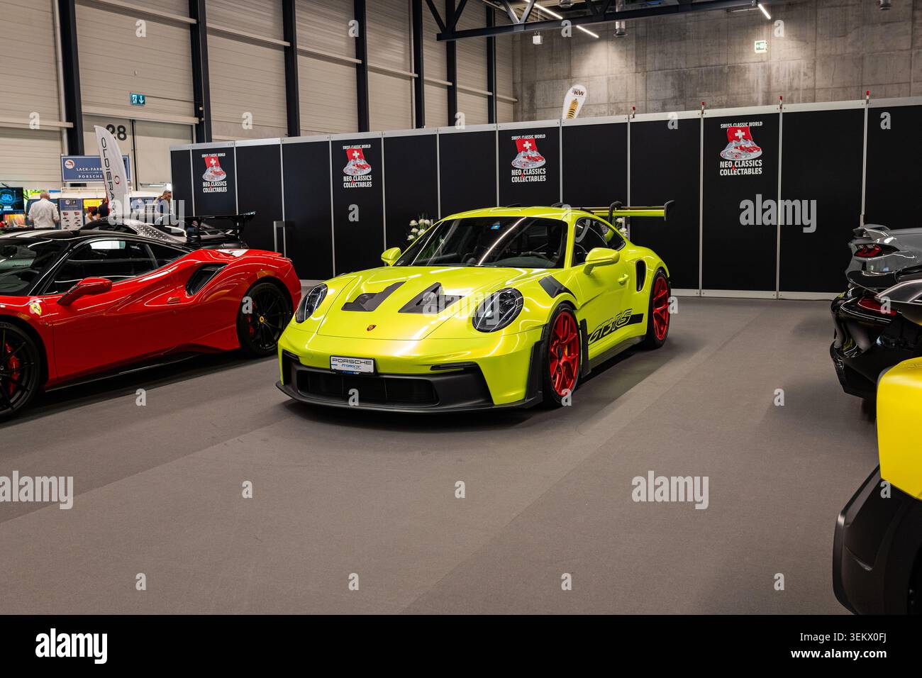 Lucerna, Svizzera, 30 maggio 2026. Una Porsche 911 GT3 RS di generazione 992 verde lime brillante con cerchi rossi è esposta accanto a una Ferrari rossa all'interno Foto Stock