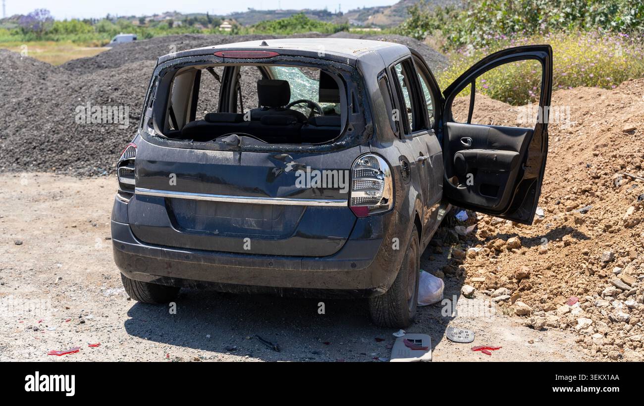 Auto abbandonata danneggiata con finestrini rotti nel cantiere Foto Stock