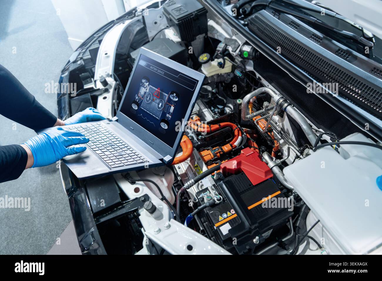 Il tecnico controlla il pacco batterie di un'auto elettrica presso un centro di assistenza. Foto Stock
