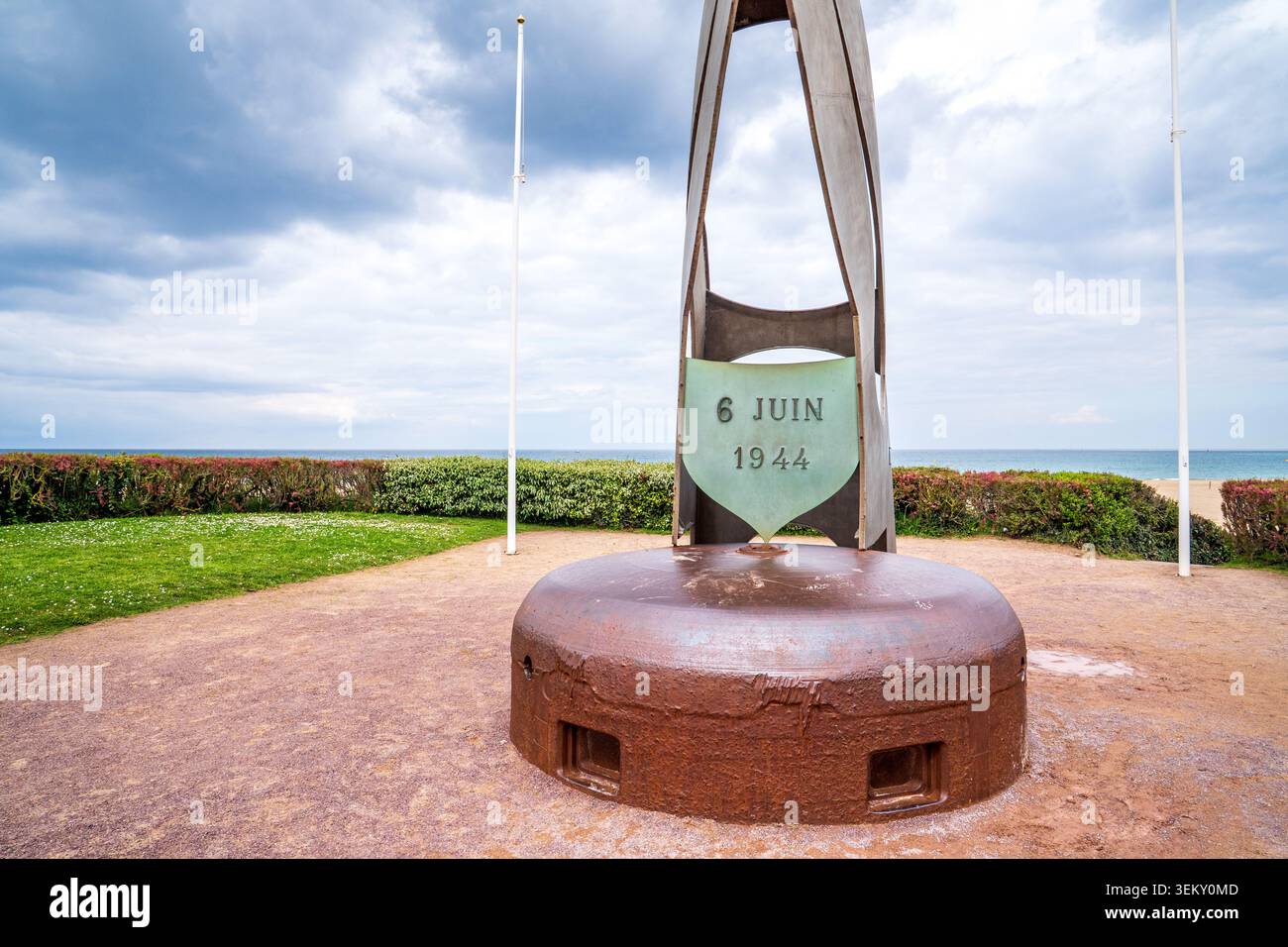 Una vista ravvicinata della torretta bunker in metallo a forma di cupola e dello scudo commemorativo inciso con 6 Juin 1944 a Lion-sur-Mer, Sword Beach. Il backg Foto Stock