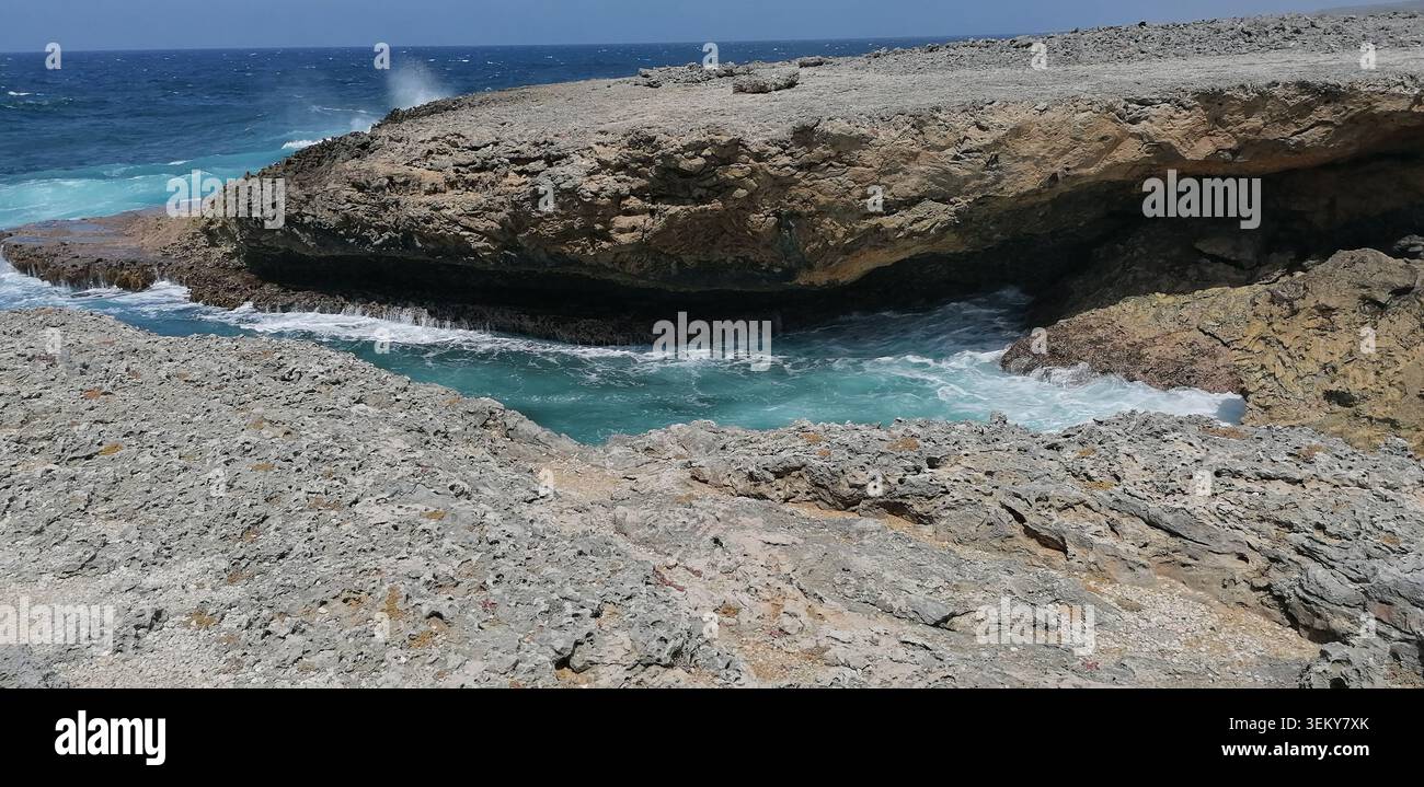Aspra costa calcarea sulla costa settentrionale di Curacao, dove le potenti onde caraibiche si infrangono contro scogliere rocciose e formazioni marine naturali. - Immagine stock catturata con smartphone