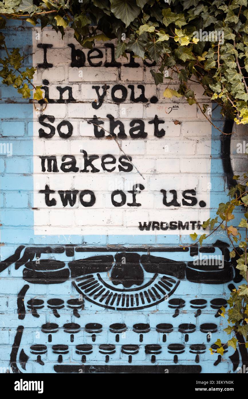 Un murale tipografico con una citazione testuale che io credo in te. Quindi siamo in due, ricoperti di edera verde che scende, Londra Foto Stock