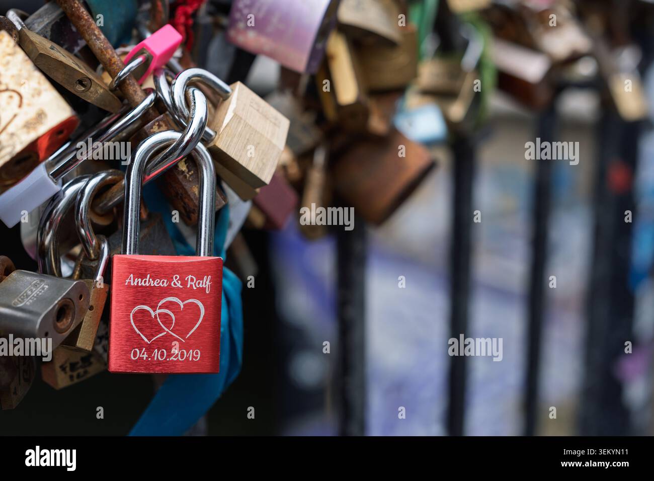 Dettaglio ravvicinato di decine di serrature d'amore incise con messaggi e simboli fissati su una ringhiera metallica a maglia, Camden Town, Londra Foto Stock