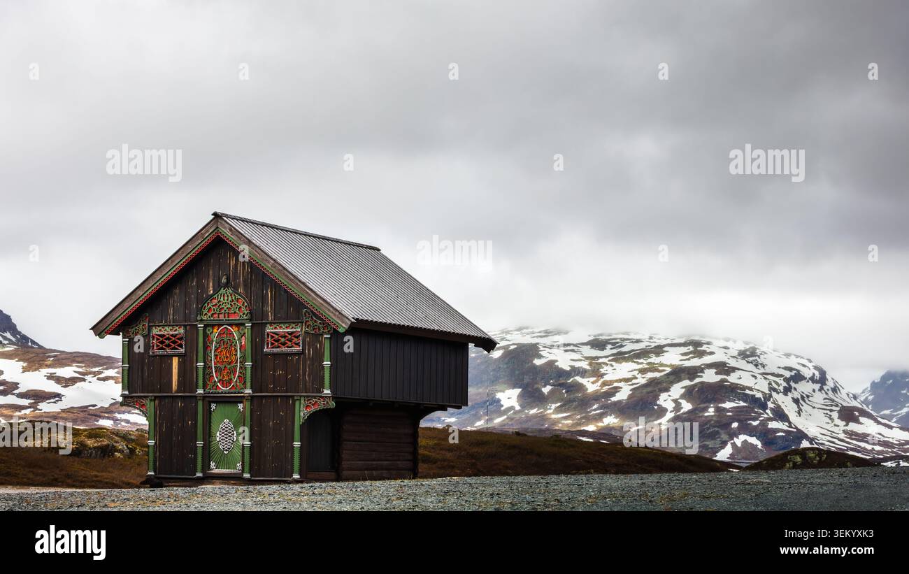 Patrimonio nordico all'aperto espresso da un tradizionale rifugio di montagna circondato da un terreno innevato e da un clima che cambia attraverso il monte Haukeli in N Foto Stock