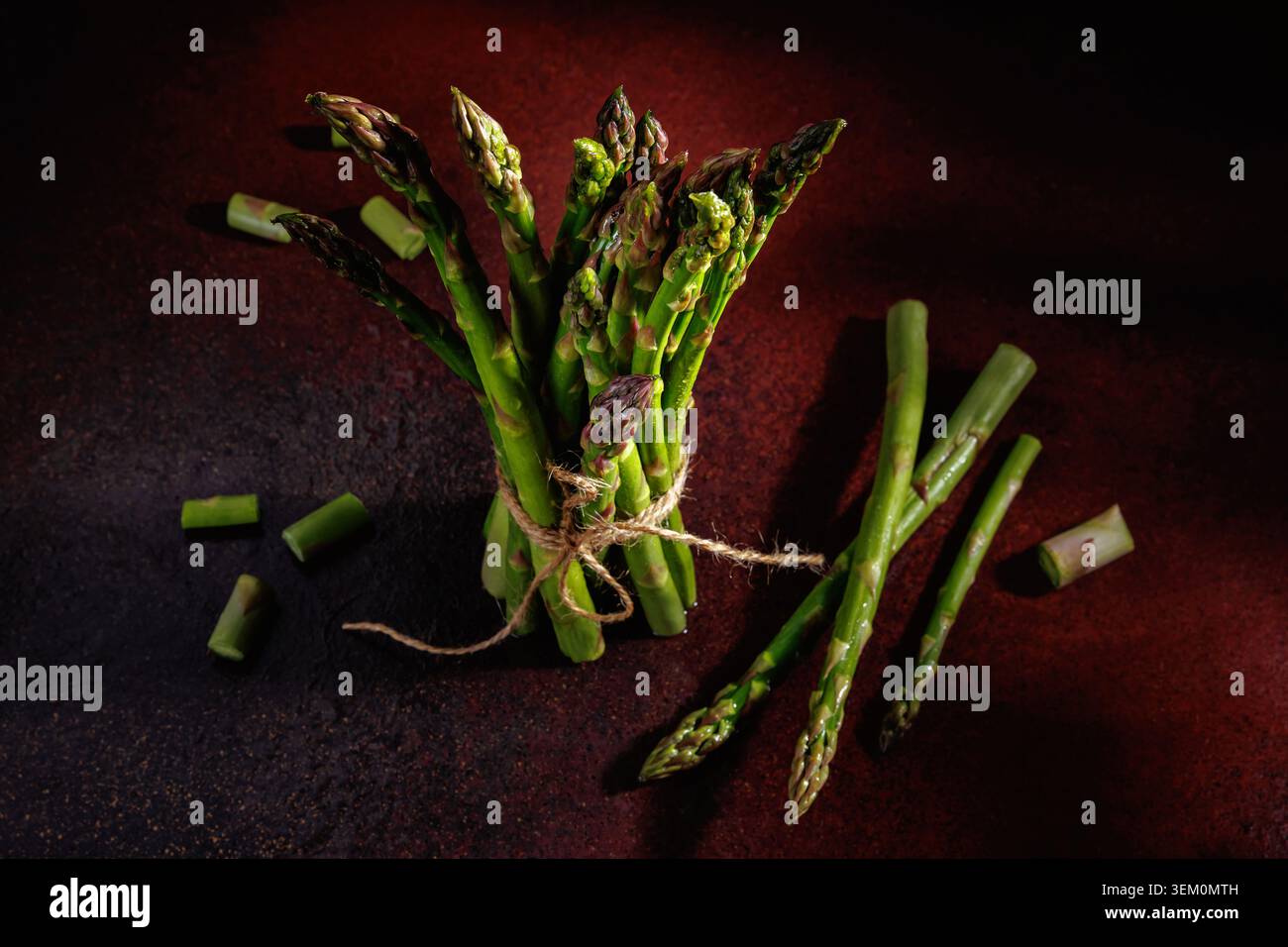 Asparagi con steli tagliati su sfondo rustico Foto Stock