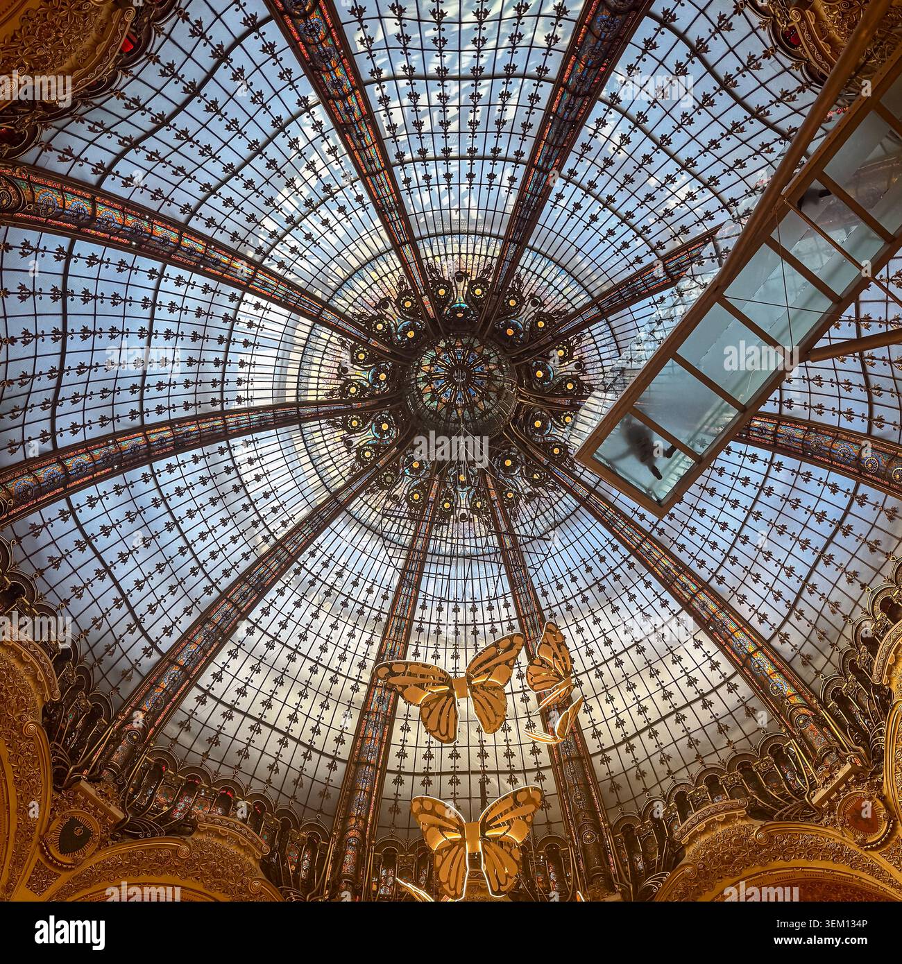 Cupola in vetro ornata in stile Art Nouveau e decorazioni a farfalla sospese all'interno delle Galeries Lafayette Haussmann a Parigi, Francia. Foto Stock