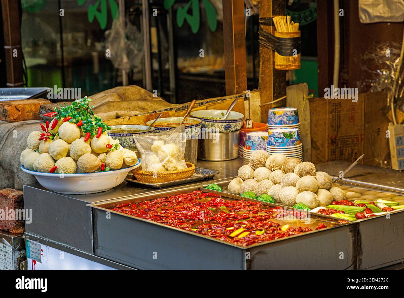 Colorato banco di cibo di strada che vende gnocchi e polpette con salsa piccante a Xi'an, Cina Foto Stock