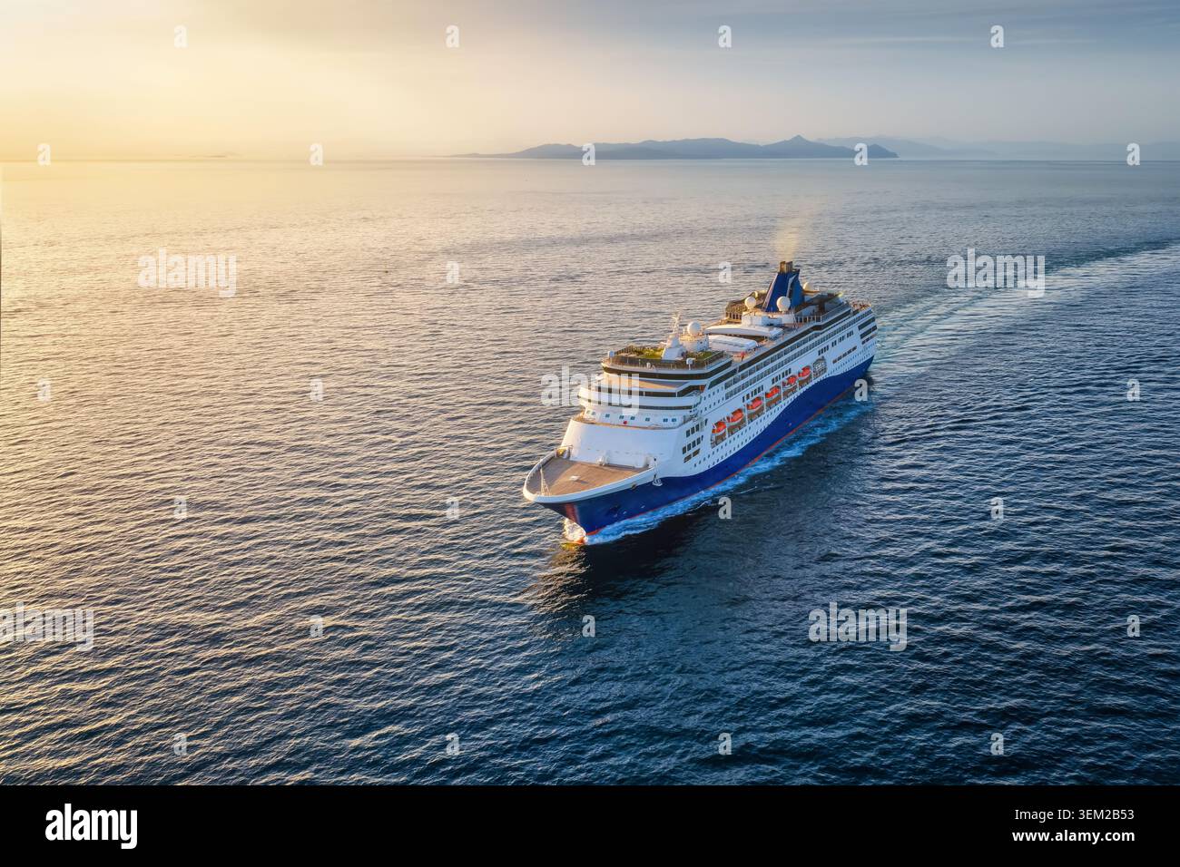 Vista aerea di una nave da crociera o di una nave passeggeri che naviga sull'oceano calmo fino al tramonto dorato con spazio fotocopie Foto Stock