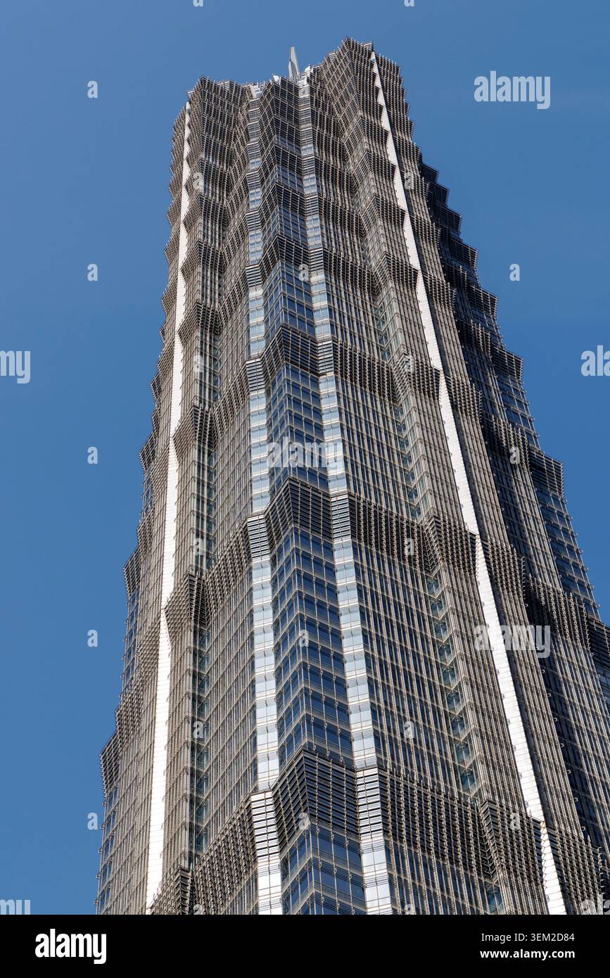 Primo piano ad angolo basso della facciata in vetro e acciaio della Jin Mao Tower che si staglia nel cielo blu di Shanghai, Cina Foto Stock