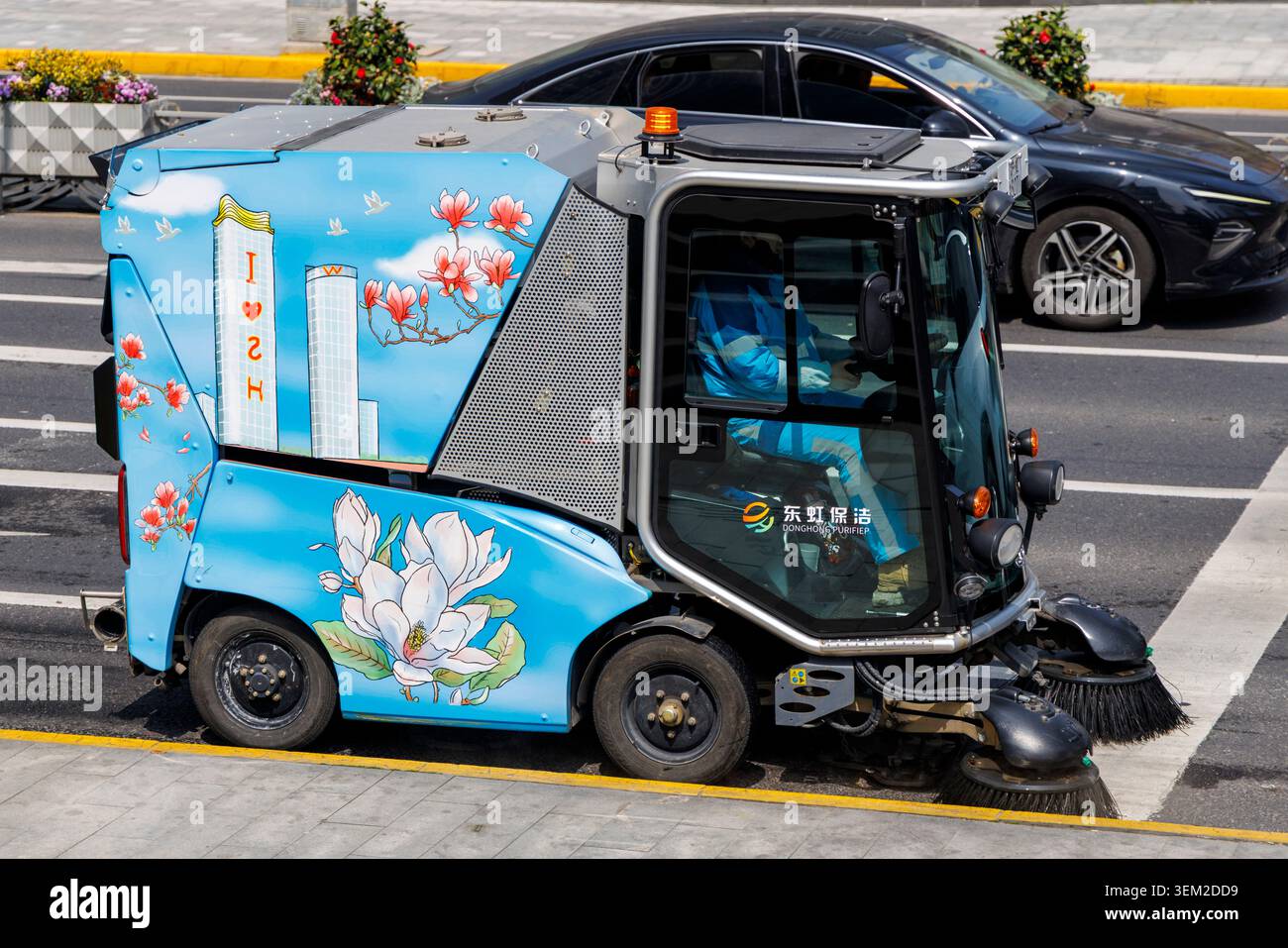 La colorata spazzatrice stradale elettrica con opere d'arte di Shanghai magnolia si ferma all'incrocio, in Cina Foto Stock