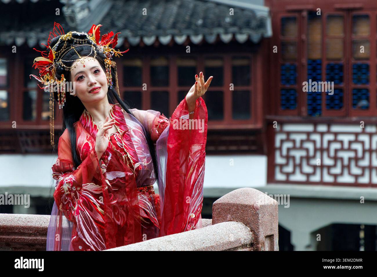 Donna con abito rosso Hanfu e copricapo ornato al Yu Garden, Shanghai, Cina Foto Stock