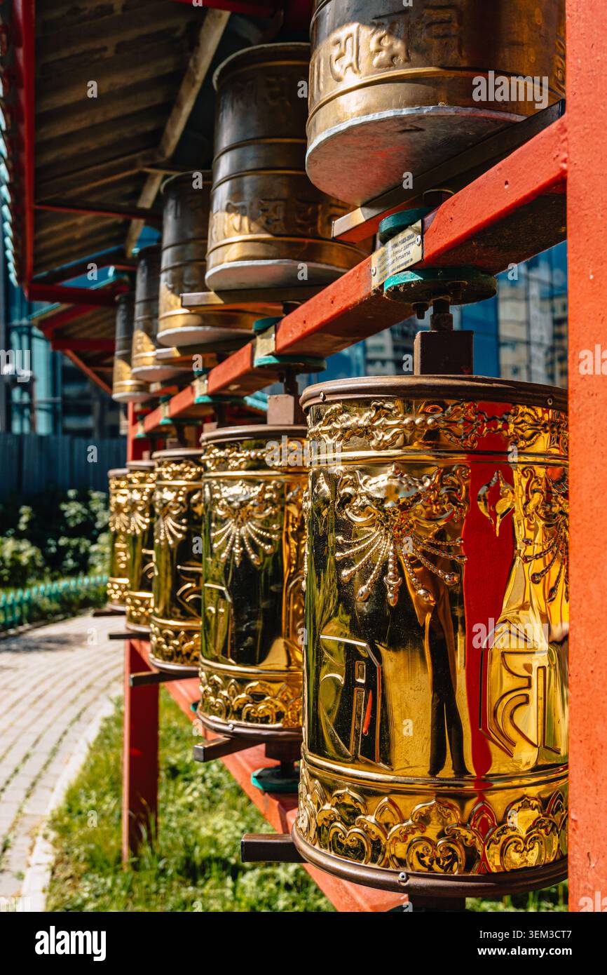 File di ruote di preghiera buddiste dorate e di bronzo ornate al monastero di Dashchoilin a Ulaanbaatar, Mongolia. Foto Stock