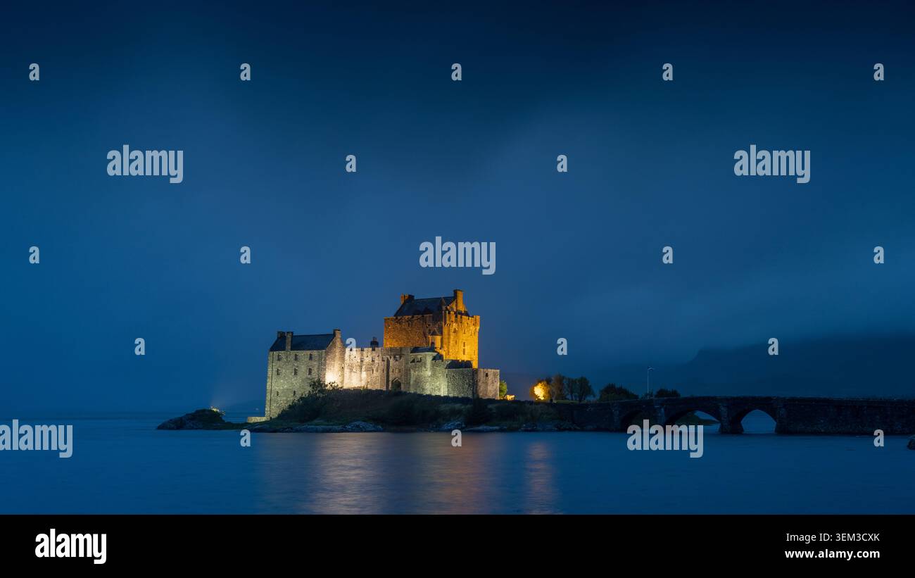 Castello di Eilean Donan nelle Highlands scozzesi al crepuscolo, Dornie, Highland, Scozia, che mostra il famoso castello dell'isola accanto a Loch Duich Foto Stock