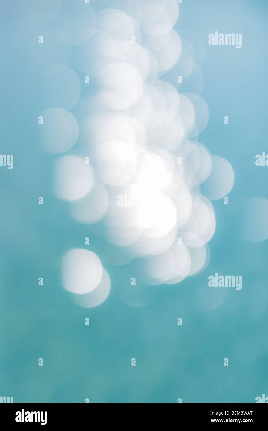 Superficie dell'acqua scintillante con luce di bokeh morbida su mare turchese, natura astratta. Dettagli scintillanti dell'oceano. Design di sfondo estivo, spazio di copia verticale Foto Stock