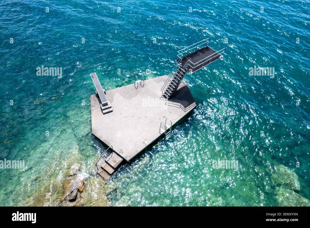 Vista aerea di una piattaforma esagonale in cemento con scale e tavole da immersione nelle acque turchesi del lago di Ginevra a Lutry, Vaud, Svizzero Foto Stock