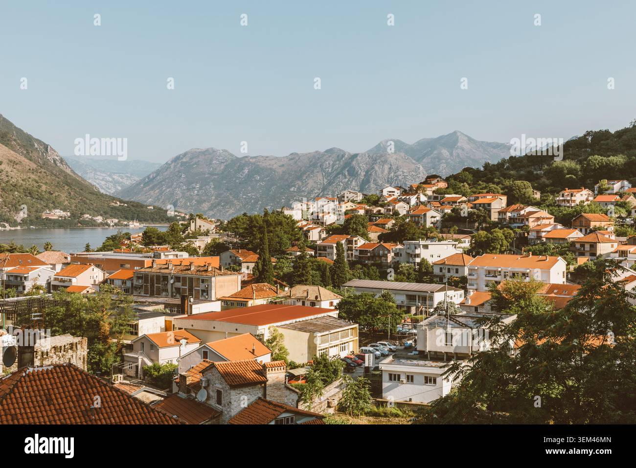 Ampia vista panoramica su Cattaro con tetti in terracotta, verdi colline e aspre montagne sopra la baia di Cattaro, Montenegro, in una giornata di sole limpido Foto Stock