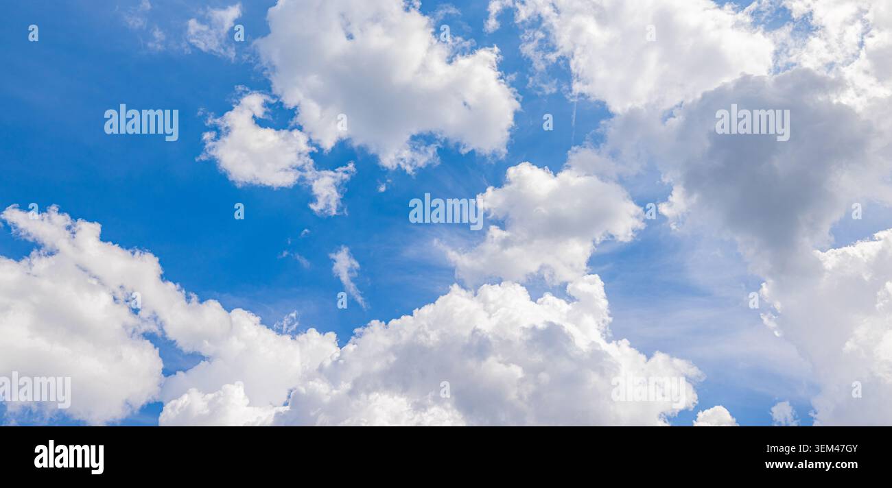 Nuvole bianche sparse che si muovono attraverso un cielo blu luminoso in una limpida giornata estiva. Paesaggio nuvoloso soleggiato. Cielo nuvole sfondo naturale paradiso spazio per copia Foto Stock