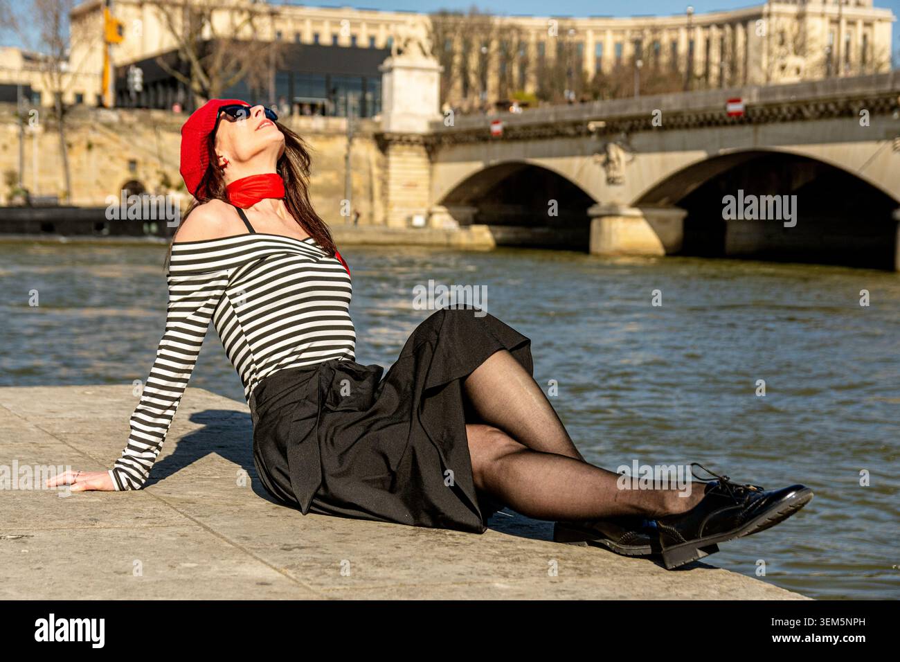 Donna che si gode un'esperienza di viaggio parigina in solitaria lungo il fiume Senna Foto Stock