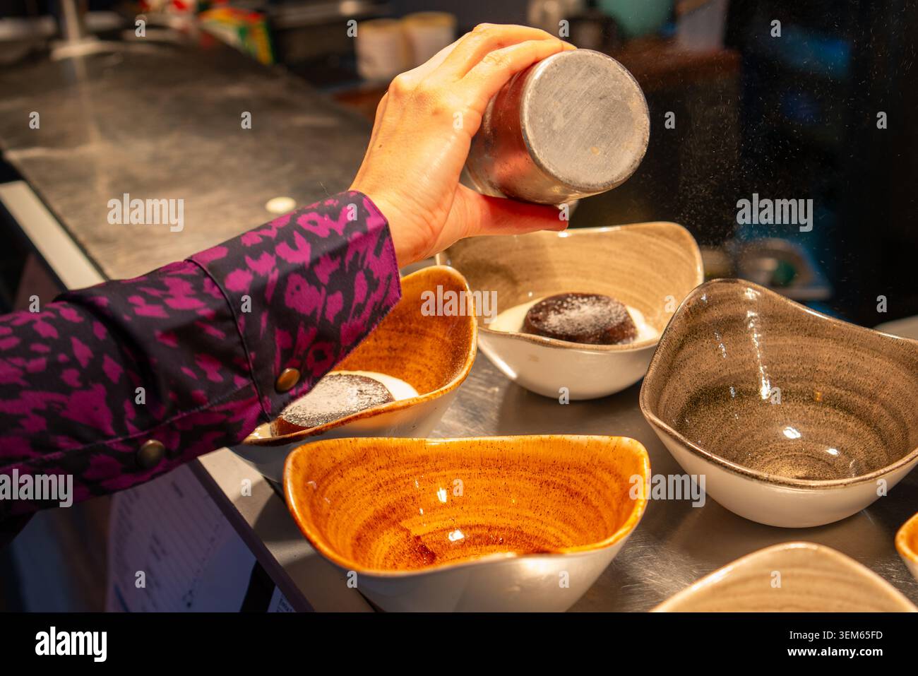 Spolverare le torte di cioccolato con zucchero a velo. Foto Stock