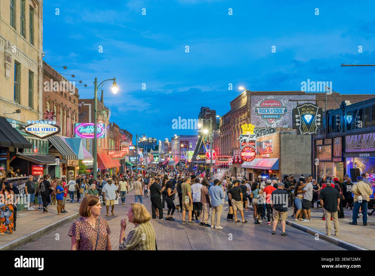 Memphis, Stati Uniti, 23 MAGGIO 2026 – Pedoni camminano lungo la strada acciottolata affollata del distretto di intrattenimento di Beale Street a Memphis, Foto Stock