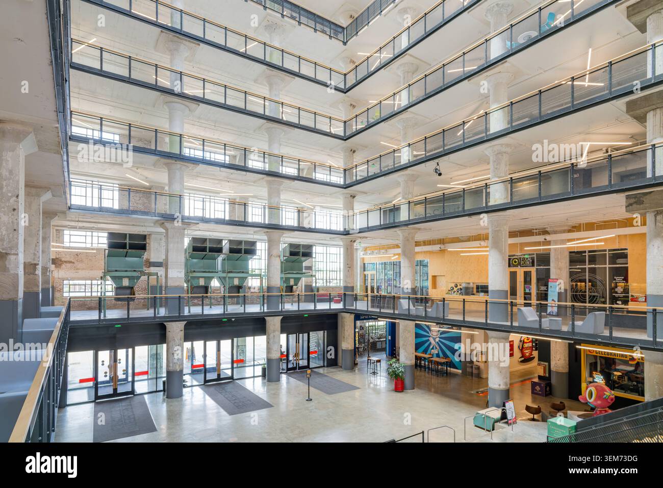 Memphis, Stati Uniti, 24 MAGGIO 2026 - Vista grandangolare di un atrio a più piani all'interno di un edificio industriale rinnovato con pilastri in cemento Foto Stock