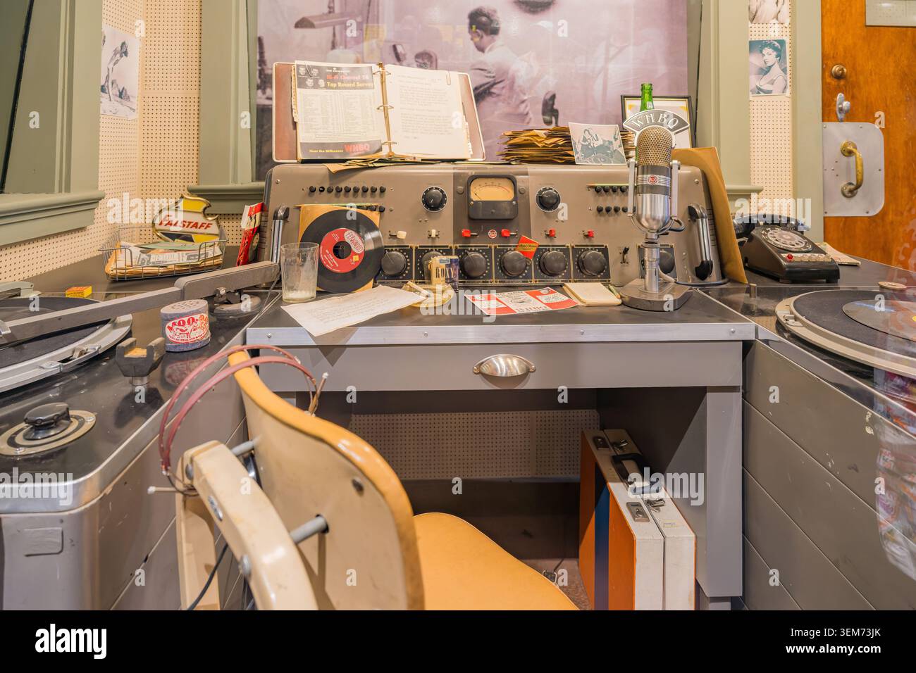Memphis, Tennessee, 24 MAGGIO 2026 - Un banco di trasmissione retrò con console di missaggio, microfono, dischi in vinile e telefono in una mostra museale. Foto Stock