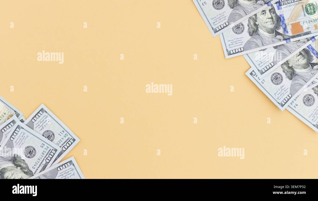 Design piatto con banconote da cento dollari sparse su uno sfondo di pesca chiaro. Perfetto per presentazioni finanziarie e mockup, offre spazio per tex Foto Stock