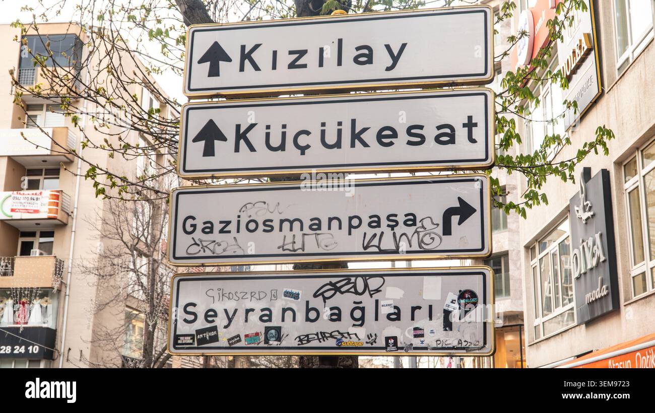 Ankara, Turchia - 12 aprile 2026: Indicazioni stradali urbane per Kizilay, Kucukesat, Gaziosmanpasa e Seyranbaglari coperte di graffiti e adesivi Foto Stock
