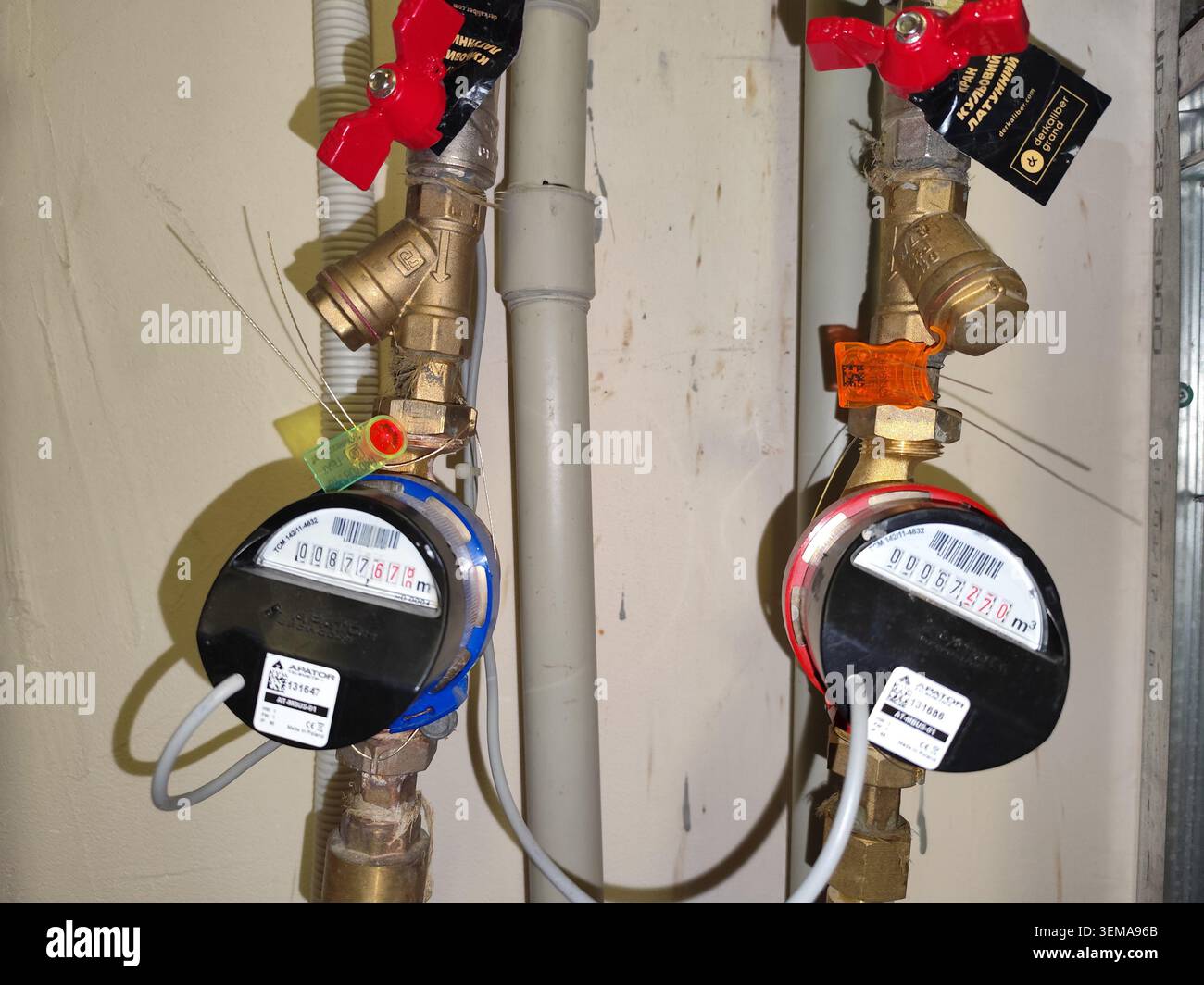 Contatori d'acqua con display digitale e sigilli di sicurezza. Misuratore di acque fredde e calde dotato di moduli elettronici, guarnizioni per fili e tubi idraulici in ottone per misurazioni. Kiev, Ucraina - 20 maggio 2026 Foto Stock