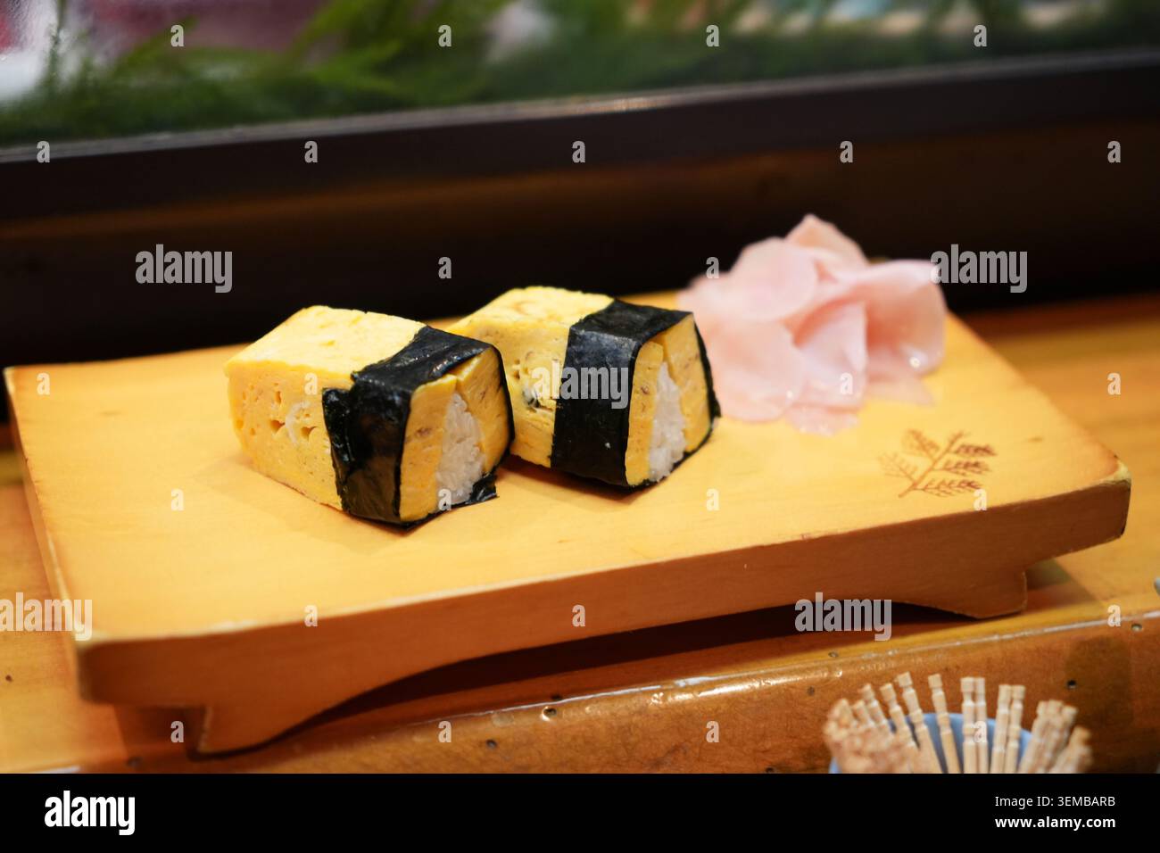 Tamago Sushi servito in un piatto di legno da un bar Izakaya Foto Stock