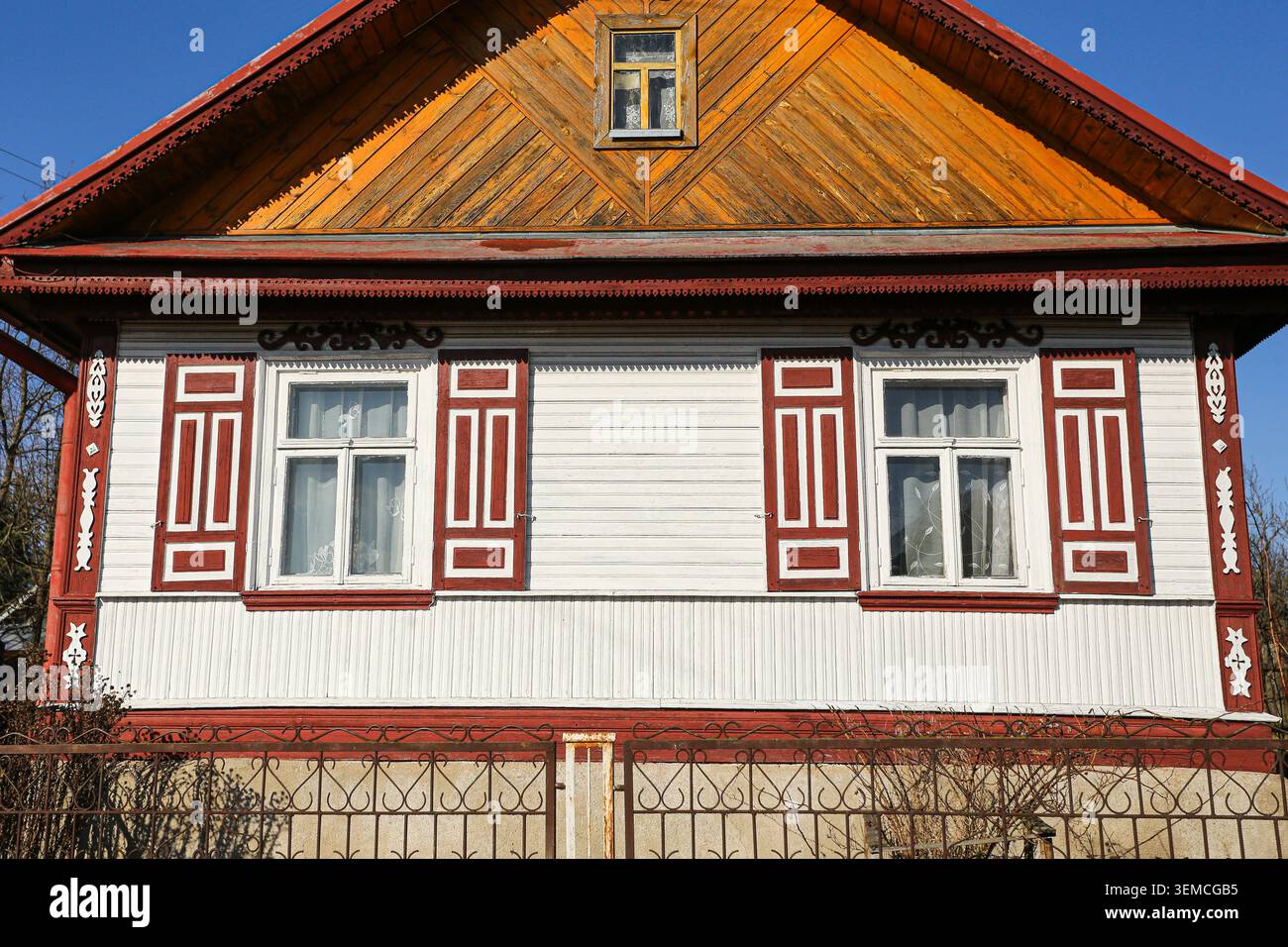 Tradizionale facciata di casa in legno con cornici decorative per finestre. Architettura regionale e concetto di patrimonio culturale all'aperto. Foto Stock