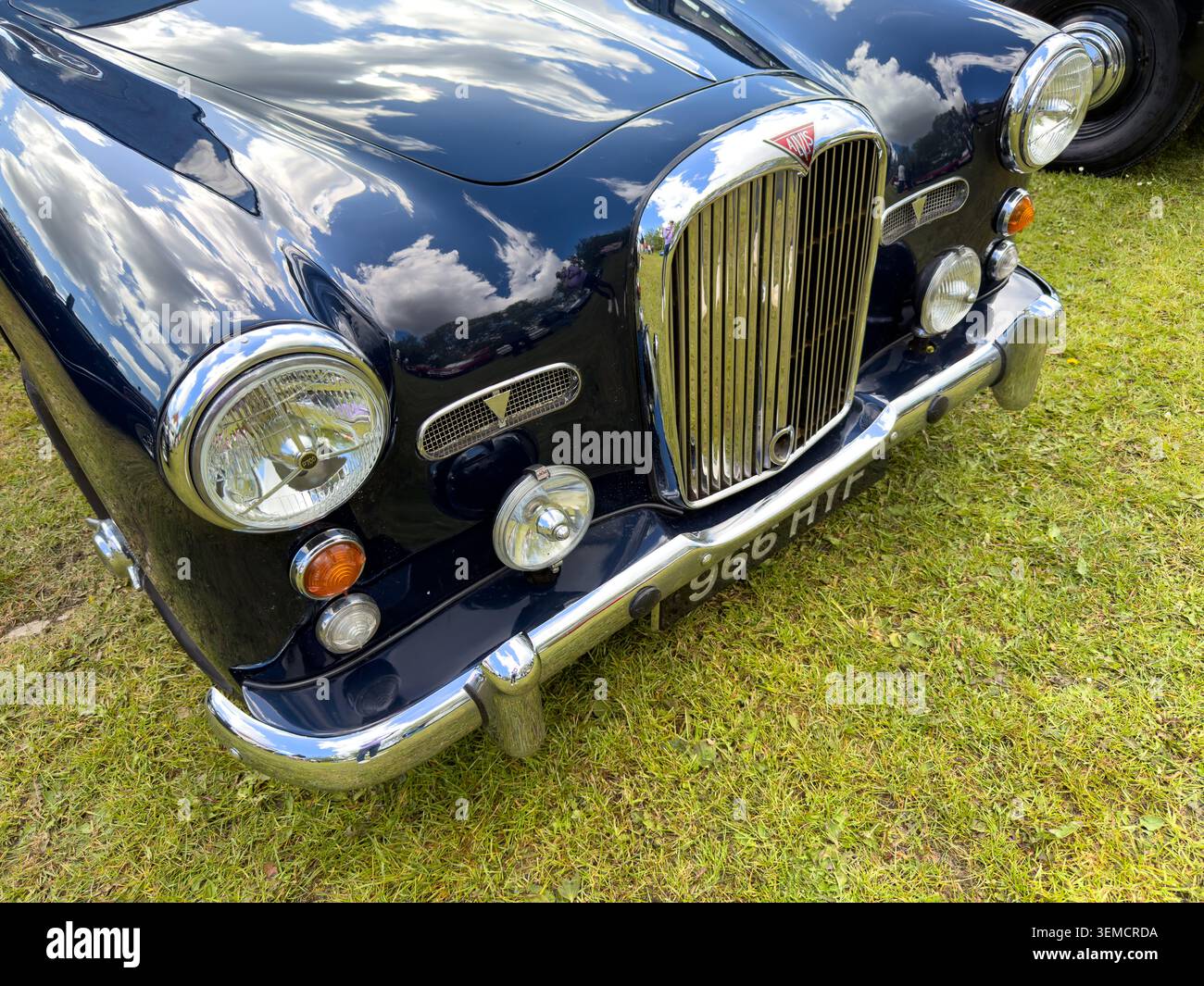 Vista frontale di una classica berlina inglese Alvis TD21 blu scuro parcheggiata sull'erba in una mostra all'aperto di veicoli d'epoca Foto Stock