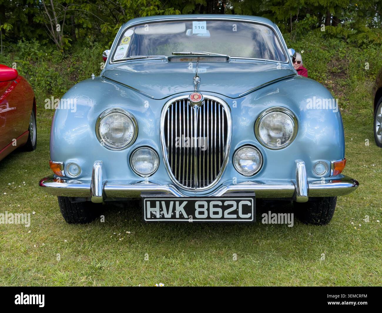 Vista frontale di una classica berlina Jaguar S-Type del 1965 di colore blu metallizzato parcheggiata sull'erba durante una mostra di auto all'aperto Foto Stock