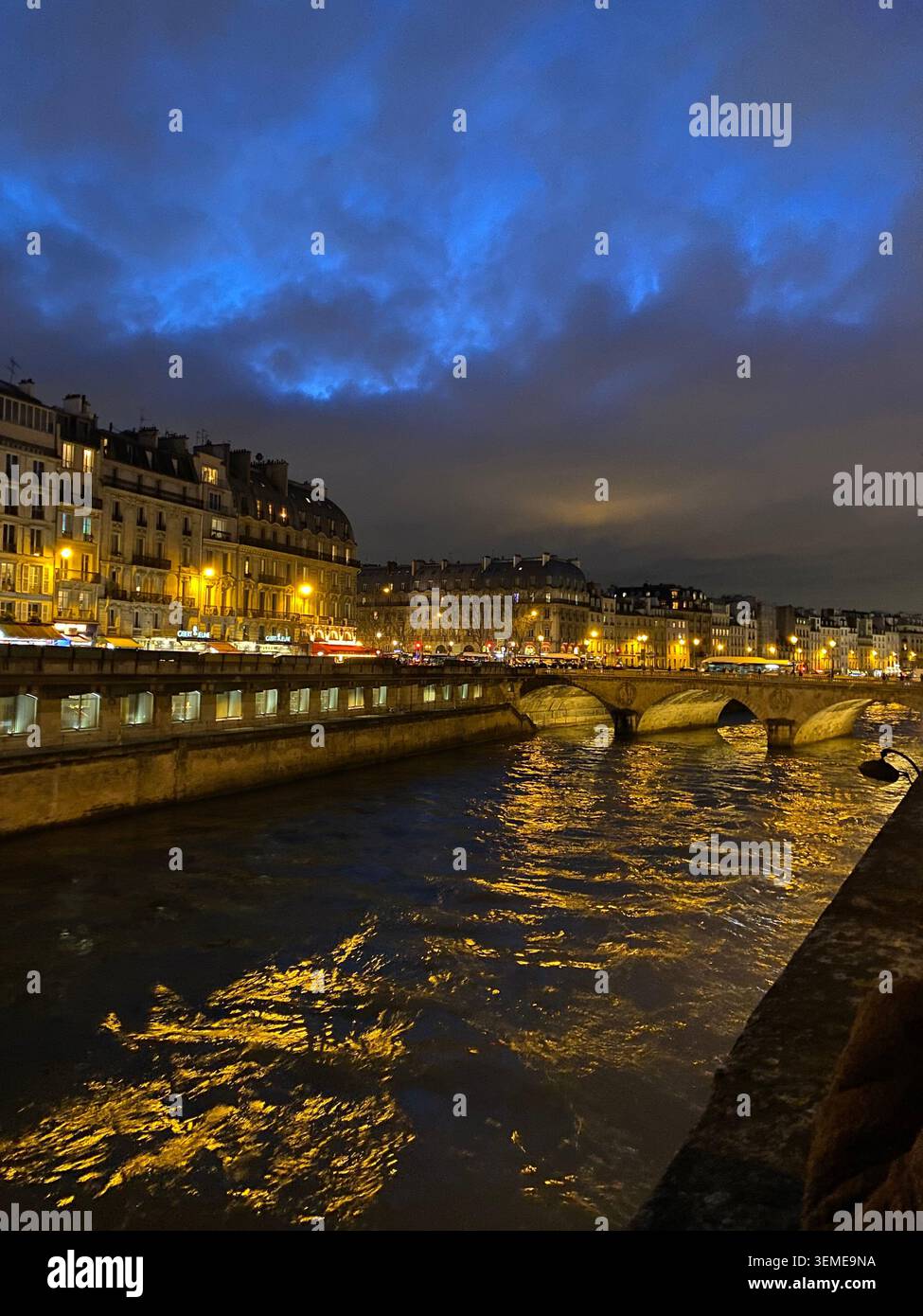 Vista notturna dell'Île de la Cité e della Senna a Parigi, Francia, con edifici illuminati lungo il fiume e riflessi del ponte. - Immagine stock catturata con smartphone