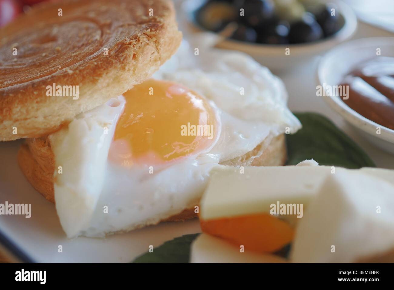 Colazione con uova fritte su panino servita con frutta Foto Stock