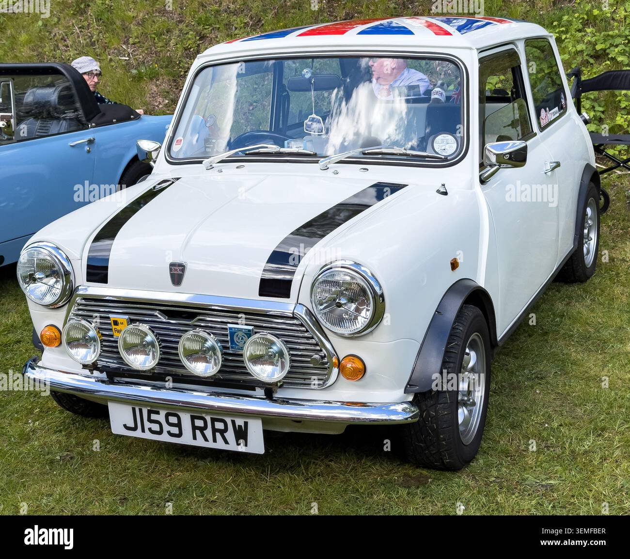 Mini Cooper Rover bianca classica con bandiera Union Jack sul tetto parcheggiata sull'erba in occasione di una mostra di auto Foto Stock