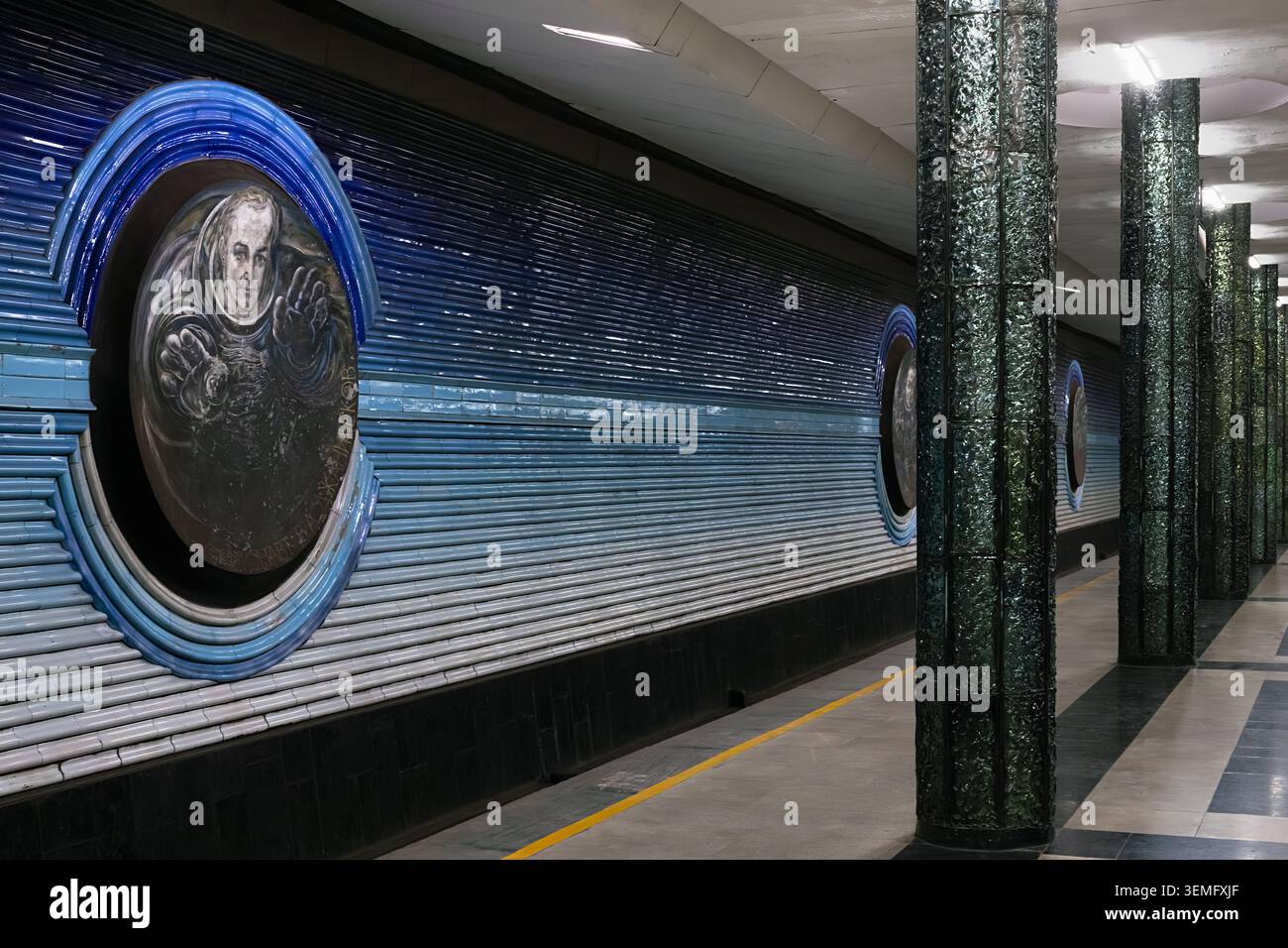 La stazione della metropolitana di Kosmonavtlar a Tashkent presenta colonne verdi e sculture ornate sul soffitto. Sala sotterranea simmetrica con pavimenti in marmo e comu Foto Stock
