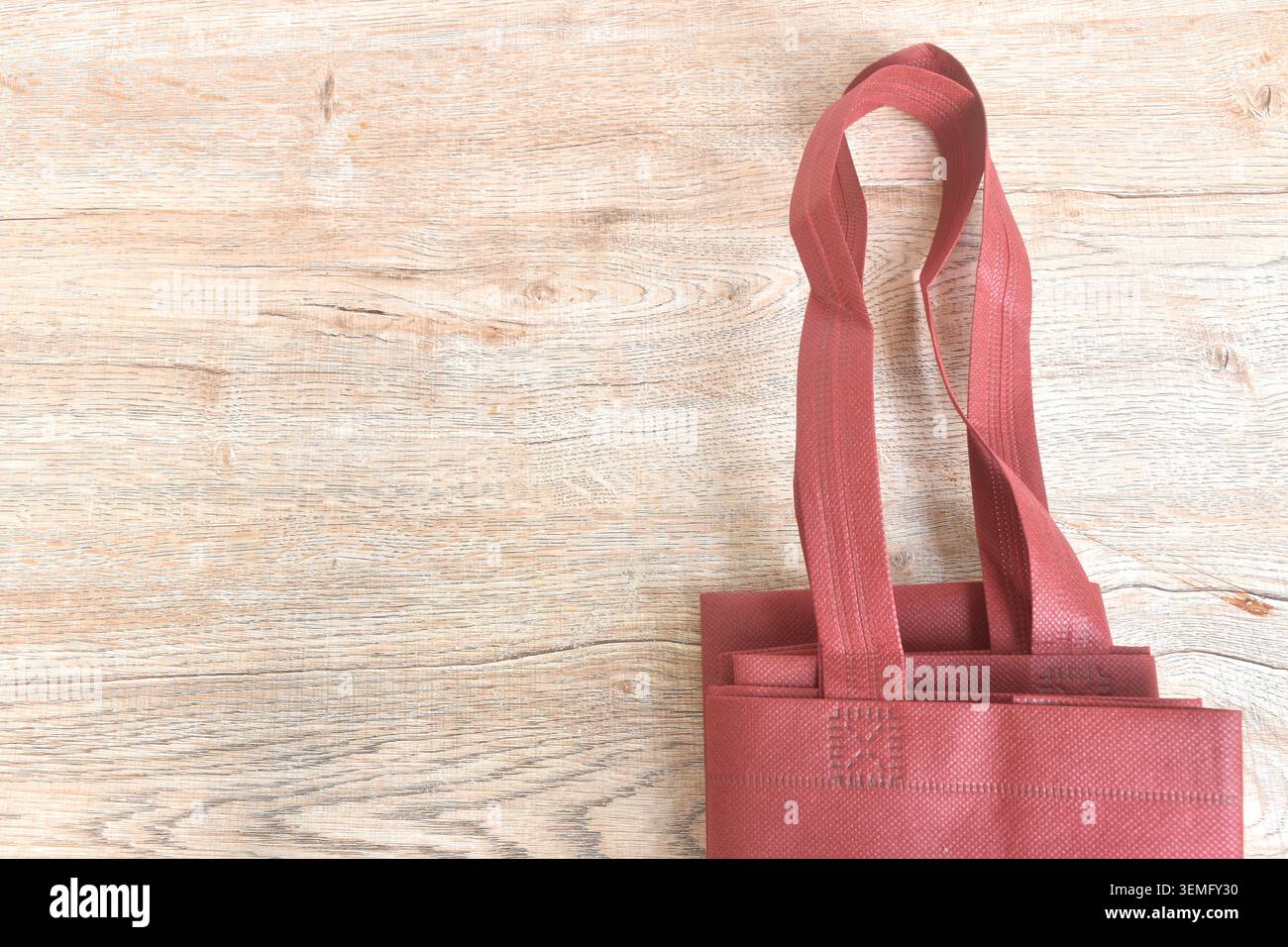 borsa in tessuto rossa sistemata sullo sfondo del tavolo e sulla consistenza Foto Stock