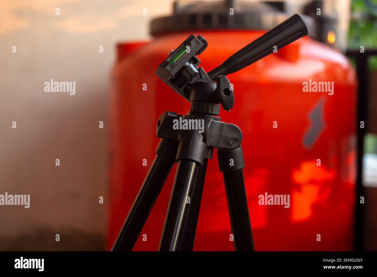 Foto ravvicinata di un treppiede nero per fotocamera in posizione interna con sfondo sfocato e profondità di campo ridotta. Foto Stock