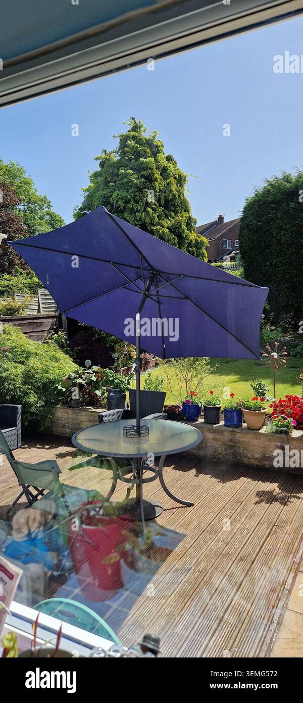 Tavolo e ombrellone all'aperto il giorno della soleggiata Foto Stock