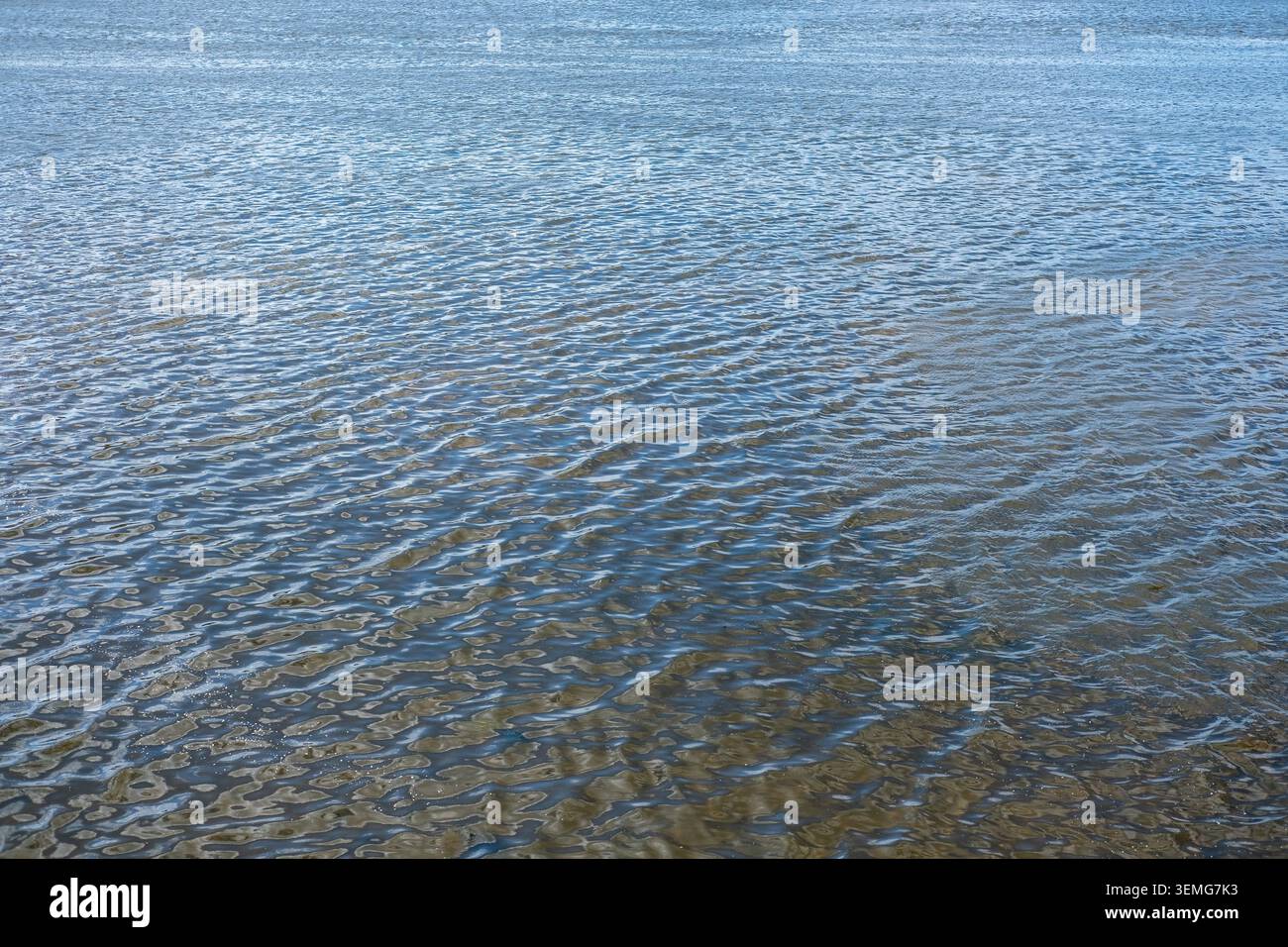 L'acqua blu sta ondulando dolcemente su un'ampia superficie del fiume. Foto Stock