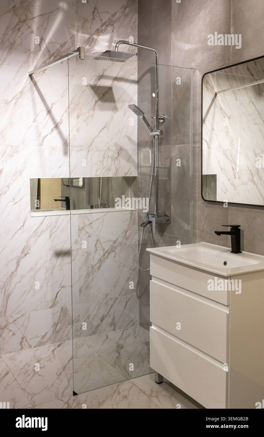 Bagno interno moderno con cabina doccia in vetro e piastrelle in marmo Foto Stock