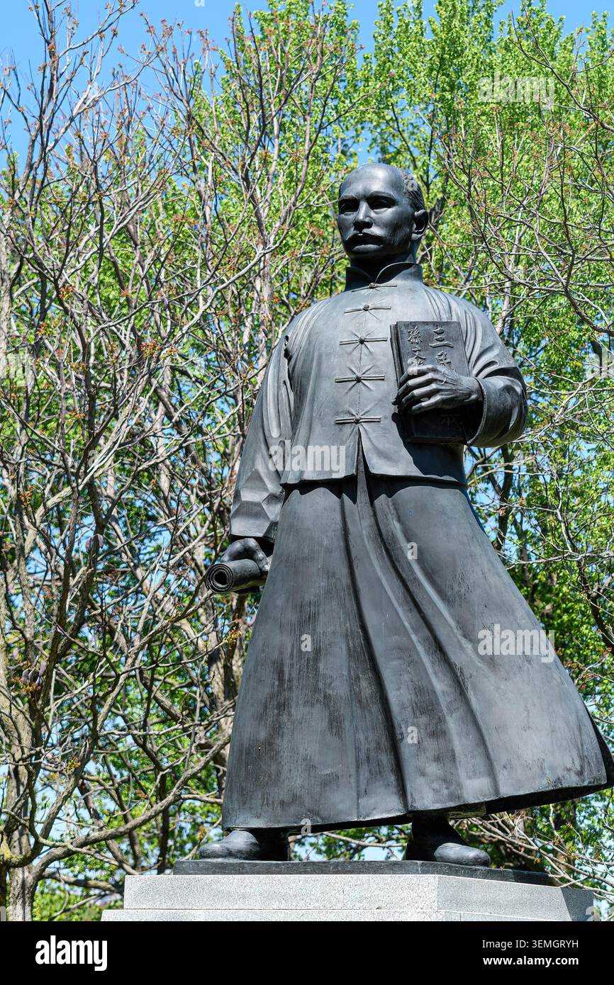 Statua a tutta altezza del Dr. Sun Yat-sen esposta all'aperto tra gli alberi nel Riverdale Park. Monumento in bronzo situato sotto un cielo primaverile luminoso. Foto Stock